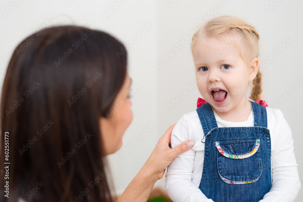 Woman speech therapist teaches a girl the correct pronunciation and literate speech Woman speech therapist teaches a girl the correct pronunciation and literate speech