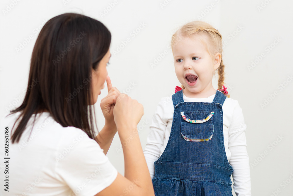 Woman speech therapist teaches a girl the correct pronunciation and literate speech