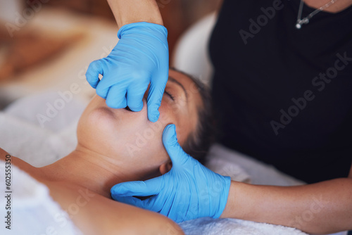Woman having mouth massage in blue gloves photo