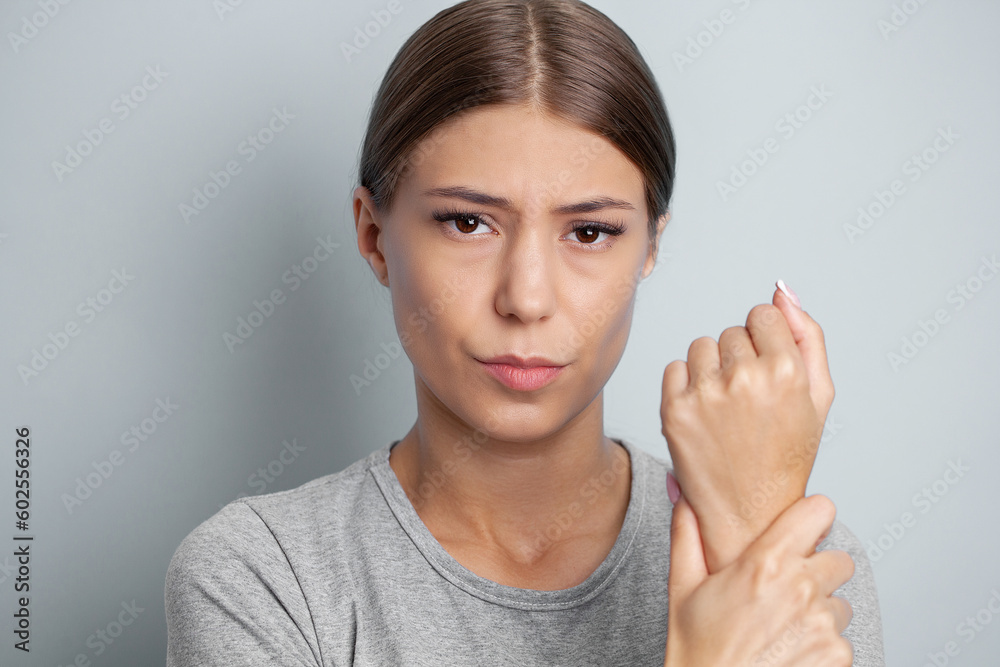 Unhappy woman suffering from pain in hand at home Unhappy woman suffering from pain in hand at home