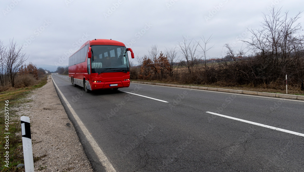 Red bus on a mountain road. Travel through the mountainous regions of the desert. tourist trip.  Touristic Red bus on highway. Red bus in the road of Serbia and green forest at sides.