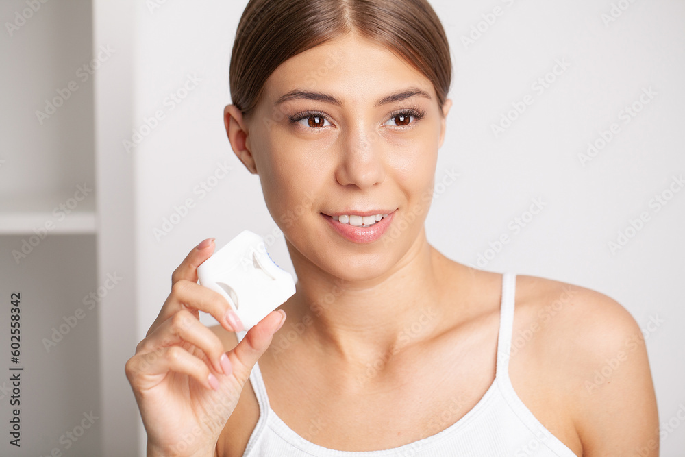 Woman using dental floss for cleaning her teeth Woman using dental floss for cleaning her teeth