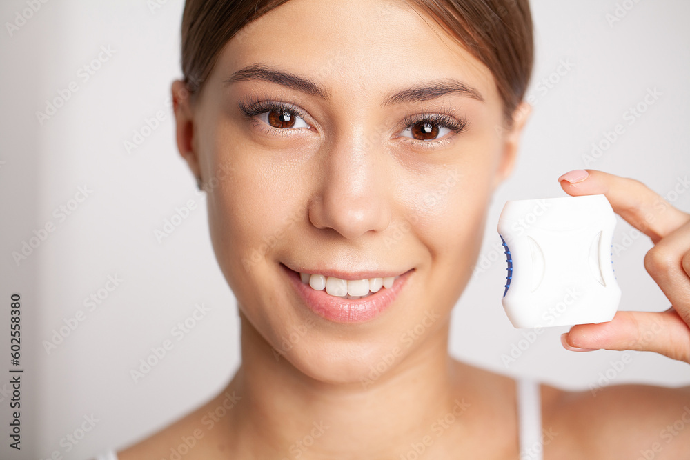 Woman using dental floss for cleaning her teeth Woman using dental floss for cleaning her teeth