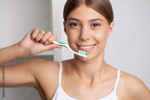 Portrait of beautiful young woman brushing teeth