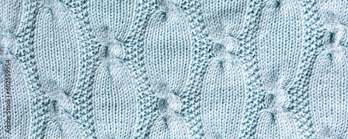 Banner with abstract turquoise cable knitted pattern background texture. Top view of knitting clothes en ball yarn