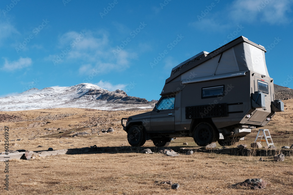 A camper in front of Mount Aragats on sunny autumn day. Aragatsotn Province, Armenia.