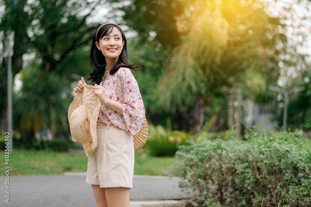Portrait of asian young woman traveler with weaving hat and basket happy smile on green public park nature background. Journey trip lifestyle, world travel explorer or Asia summer tourism concept. Portrait of asian young woman traveler with weaving hat and basket happy smile on green public park nature background. Journey trip lifestyle, world travel explorer or Asia summer tourism concept.