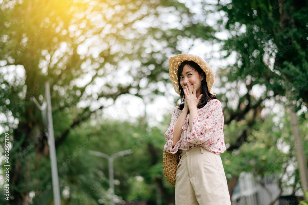 Portrait of asian young woman traveler with weaving hat and basket happy smile on green public park nature background. Journey trip lifestyle, world travel explorer or Asia summer tourism concept. Portrait of asian young woman traveler with weaving hat and basket happy smile on green public park nature background. Journey trip lifestyle, world travel explorer or Asia summer tourism concept.