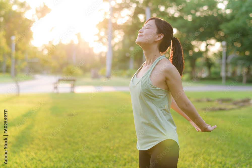Female jogger. Fit young Asian woman with green sportswear breathing fresh air in park before running and enjoying a healthy outdoor. Fitness runner girl in public park. Wellness being concept Female jogger. Fit young Asian woman with green sportswear breathing fresh air in park before running and enjoying a healthy outdoor. Fitness runner girl in public park. Wellness being concept