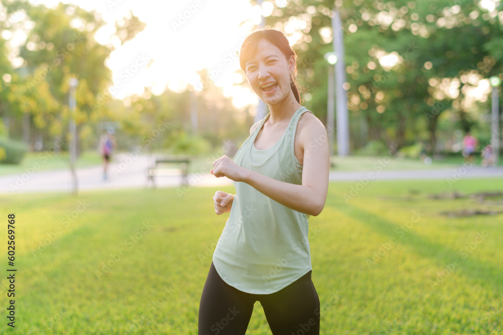 Female jogger. Fit young Asian woman with green sportswear stretching muscle in park before running and enjoying a healthy outdoor. Fitness runner girl in public park. Wellness being concept Female jogger. Fit young Asian woman with green sportswear stretching muscle in park before running and enjoying a healthy outdoor. Fitness runner girl in public park. Wellness being concept