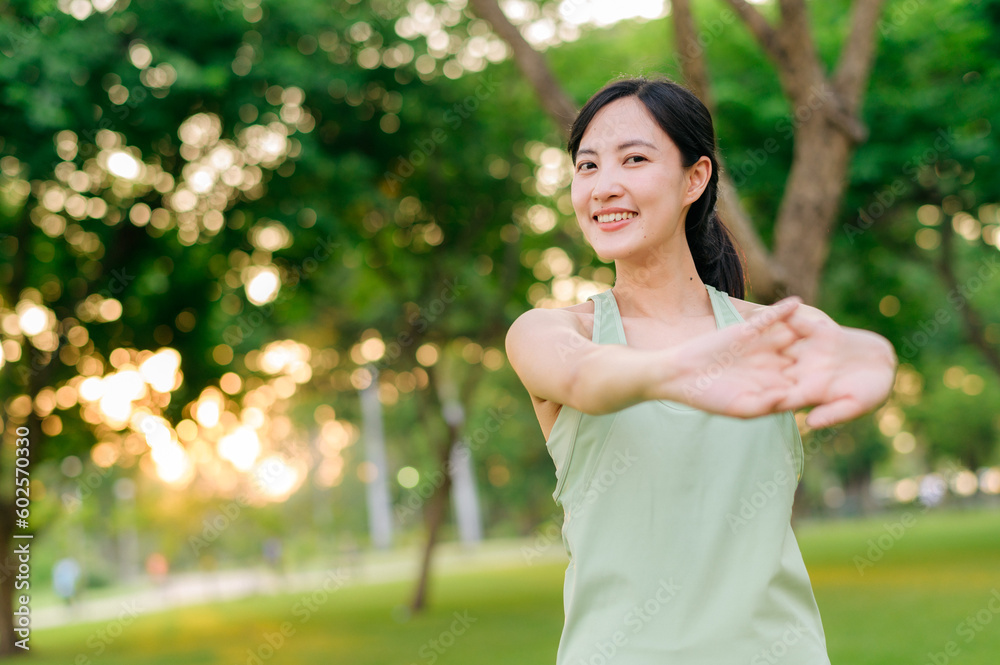 Female jogger. Fit young Asian woman with green sportswear stretching muscle in park before running and enjoying a healthy outdoor. Fitness runner girl in public park. Wellness being concept Female jogger. Fit young Asian woman with green sportswear stretching muscle in park before running and enjoying a healthy outdoor. Fitness runner girl in public park. Wellness being concept
