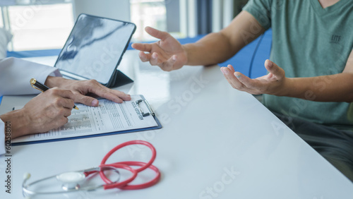 Tableau sur toile Male doctor is consulting with a young man about prostate cancer and venereal disease and sexual dysfunction about the causes of erectile dysfunction in an examination room