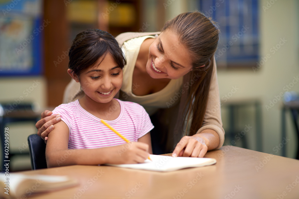 School, education or study with a student and teacher in a classroom together for writing or child development. Learning, scholarship and teaching with a woman educator helping a girl child in class School, education or study with a student and teacher in a classroom together for writing or child development. Learning, scholarship and teaching with a woman educator helping a girl child in class