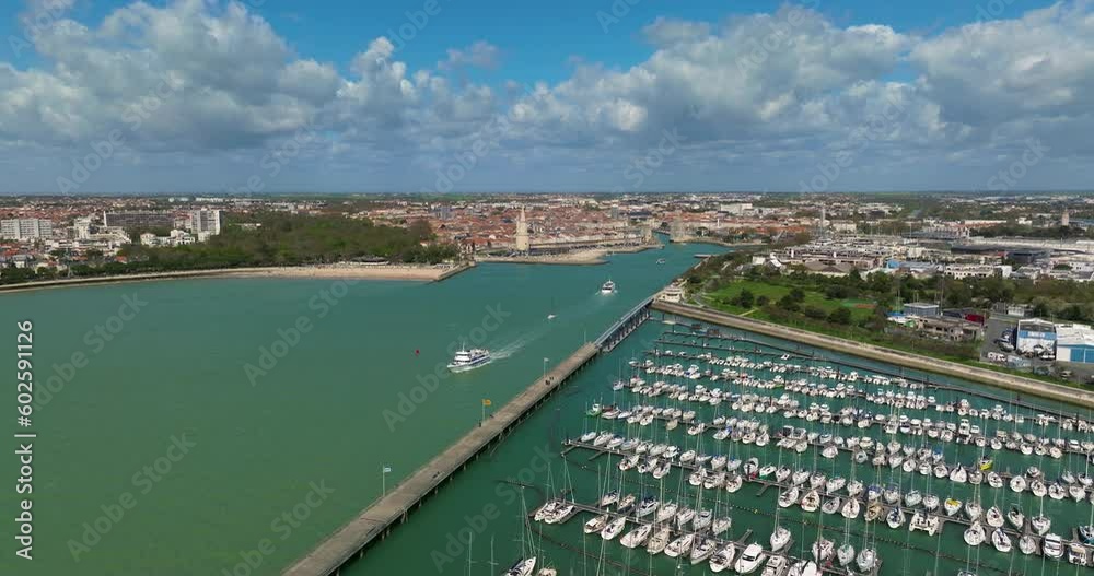 Aerial view of La Rochelle, France. The drone flies over the bay and yachts. The boat passes between the Tour de la Chiene and the Saint-Nicolas tower, aerial view from a drone