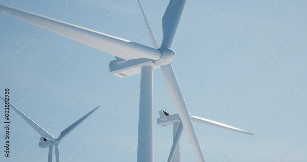 SEAMLESS LOOP Clean shot of 3 of wind turbines producing electricity against bright blue sky. Background for sustainable energy conference, website header