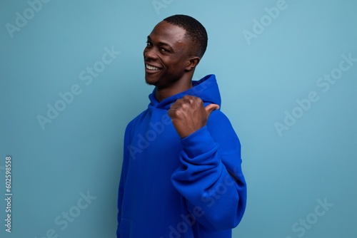authentic ethnic young african man in stylish hoodie on blue background