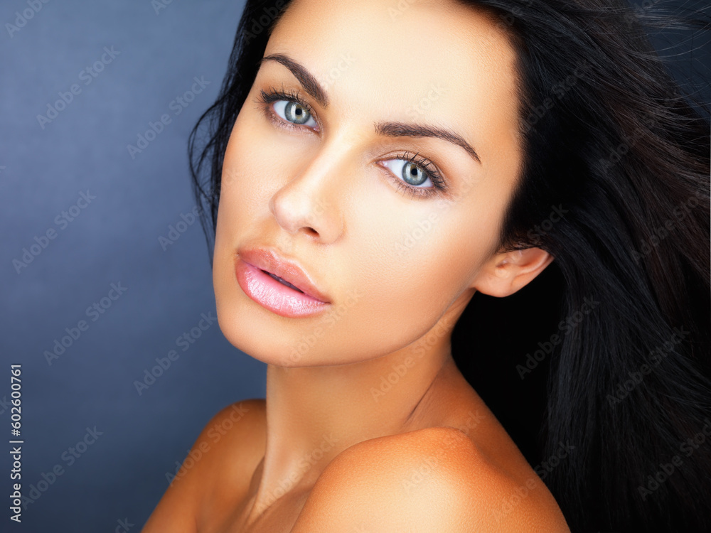 Beauty, skincare and healthy clean skin of a beautiful young woman with gorgeous blue eyes. Face portrait of a confident, aesthetic and sensual woman posing against a blue studio background Beauty, skincare and healthy clean skin of a beautiful young woman with gorgeous blue eyes. Face portrait of a confident, aesthetic and sensual woman posing against a blue studio background