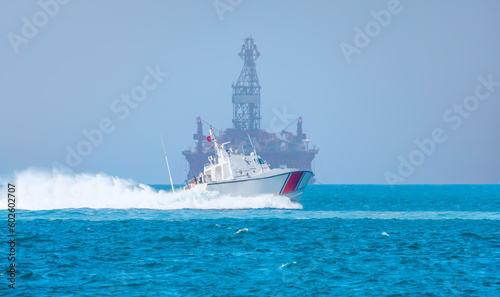 Coast Guard patrol boat rushing to the rescue - Oil and gas wellhead remote platform