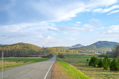 Asphalt road in the picturesque countryside on a spring evening. Travel by car.
