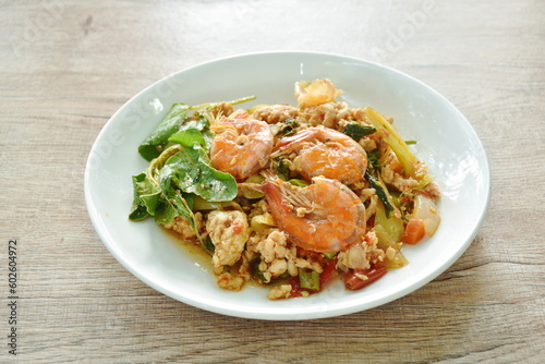 spicy chili stir fried mashed chicken and shrimp with basil leaf on plate