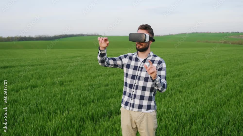 In virtual reality glasses, conception of gaming. Handsome young man is on agricultural field. In virtual reality glasses, conception of gaming. Handsome young man is on agricultural field.