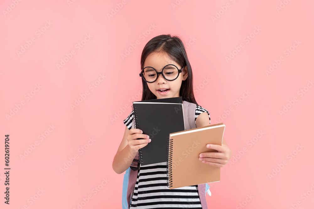 schoolgirl hugging book wearing backpack smiling isolated on pink background schoolgirl hugging book wearing backpack smiling isolated on pink background