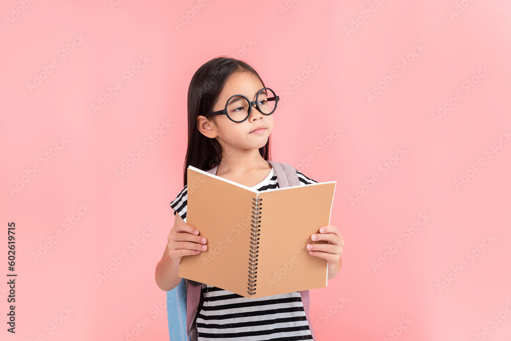 schoolgirl hugging book wearing backpack smiling isolated on pink background schoolgirl hugging book wearing backpack smiling isolated on pink background
