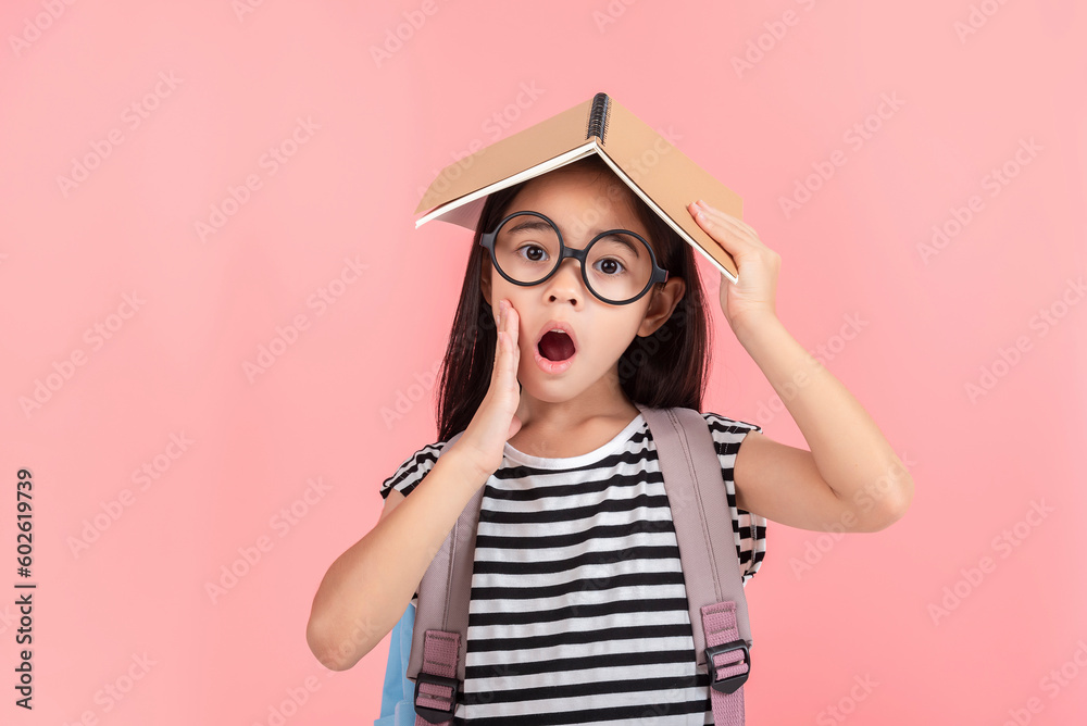schoolgirl hugging book wearing backpack smiling isolated on pink background schoolgirl hugging book wearing backpack smiling isolated on pink background