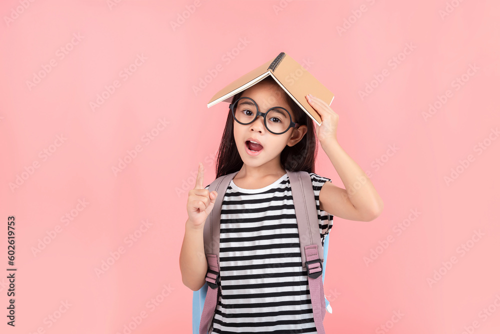 schoolgirl hugging book wearing backpack smiling isolated on pink background schoolgirl hugging book wearing backpack smiling isolated on pink background