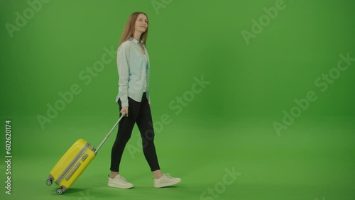 Green Screen. Chroma Key. Pretty Woman Tourist With Yellow Luggage in the Hands Passing by Looking Around. Female on Vacation Trip.