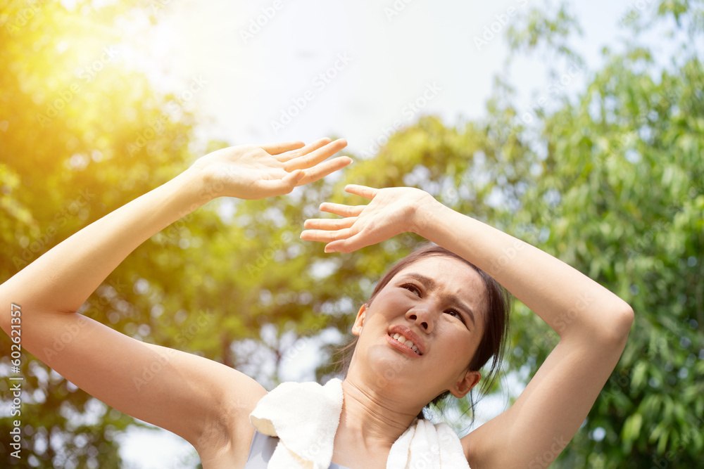 Sport asian woman gets tired and get dizzy, feel bad pain and suffer from heat stroke outdoors when jogging or exercise outdoor with strong sunlight in summer season. Heatstroke and heat wave concept. Sport asian woman gets tired and get dizzy, feel bad pain and suffer from heat stroke outdoors when jogging or exercise outdoor with strong sunlight in summer season. Heatstroke and heat wave concept.