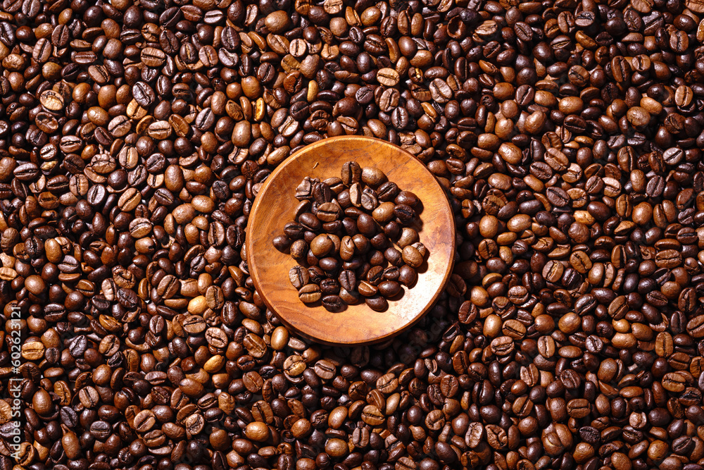 Fototapeta premium Palone ziarna kawy i drewnianym podstawkiem z mieloną kawą