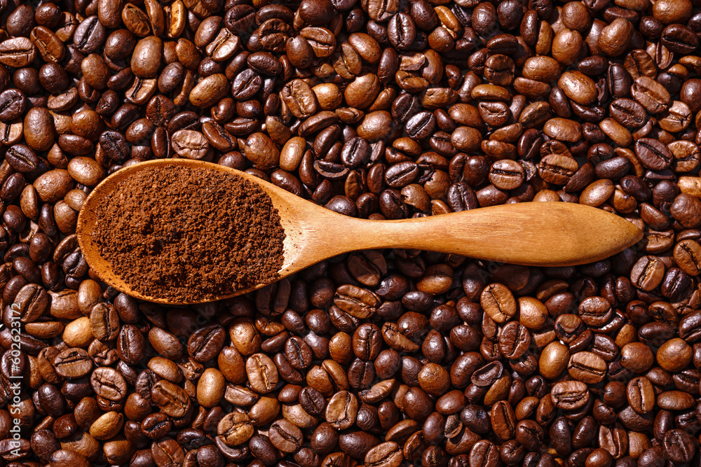 Obraz premium Palone ziarna kawy i drewnianą łyżka z mieloną kawą