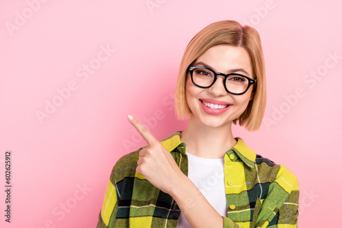 Fototapeta Naklejka Na Ścianę i Meble -  Photo portrait of lovely young lady point finger empty space specs wear trendy plaid yellow clothes isolated on pink color background