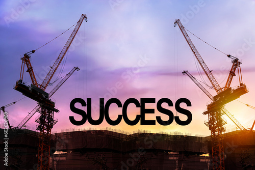 Build up success concept. Black alphabetic letters forming the word success being set up by group of construction machines.