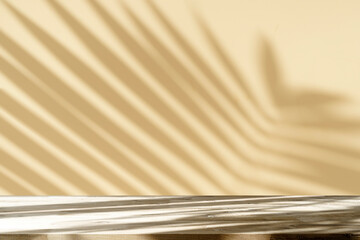 Table shadow background. Wooden table and white empty wall with plant shadows.