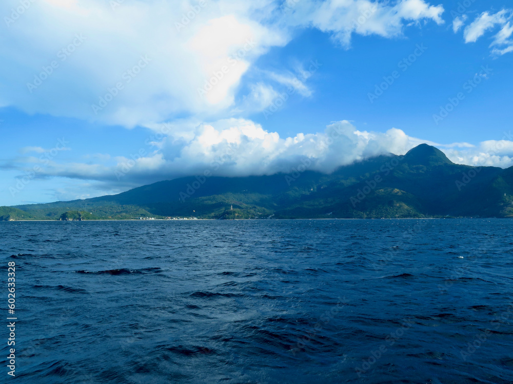 Clouds in the mountains. View of a hilly tropical island and clouds over mountains.