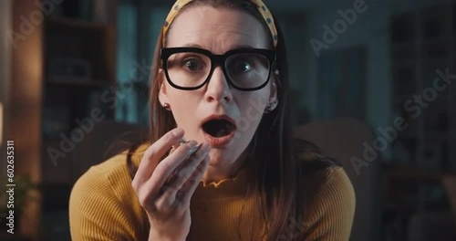 Shocked woman watching action movies on TV