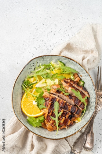salad with grilled chicken, orange, cucumber and arugula
