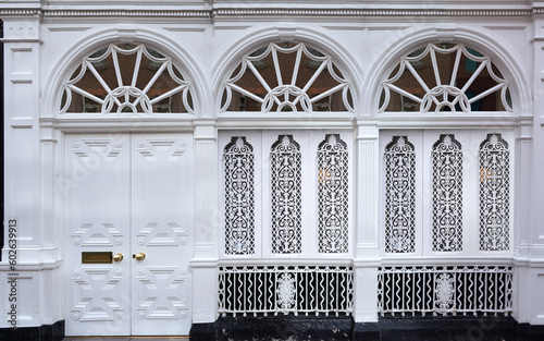 Canvas Print Front of building painted white, with fanlight windows and ornate grille
