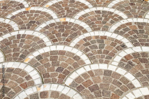 Half round bricks laid out on the sidewalk.