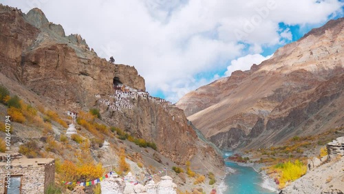 4K shot of ancient Phugtal Monastery made in a natural cave near Purne village in Zanskar, Ladakh India. Old Buddhist monastery with flowing blue Tsarap river. Nature Landscape. Travel India concept. photo