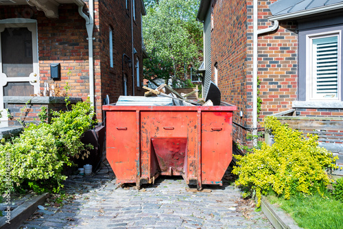 Photography A roll-off construction dumpster outside a residential renovation project in an older neighourhood