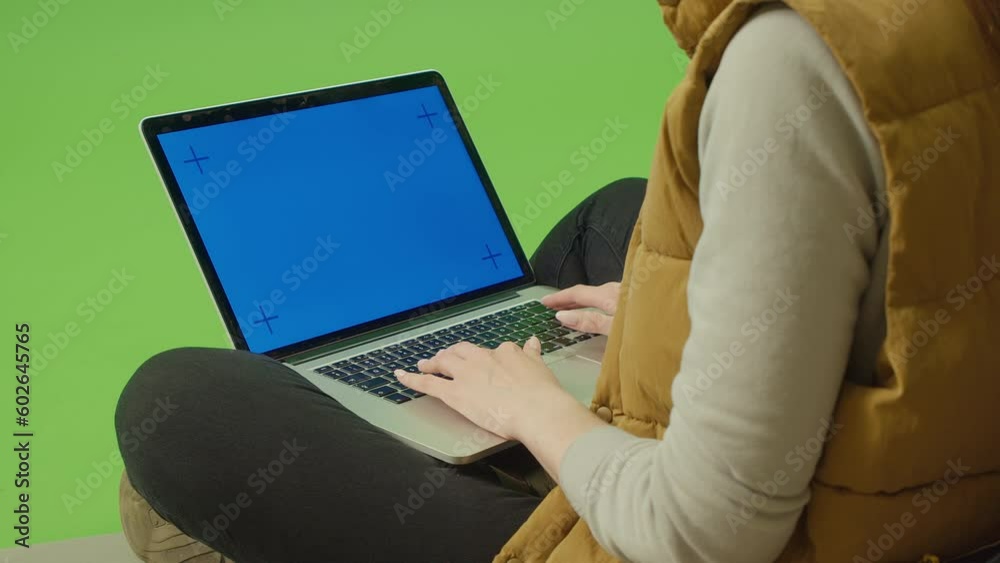 Green Screen. Chroma Key.Close-up of Female Camper Sitting in Front of Opened Tent with Laptop with Blank Blue Screen. View From inside Tent.Remote Work in Nature, Chating with Friends, Browsing Sites