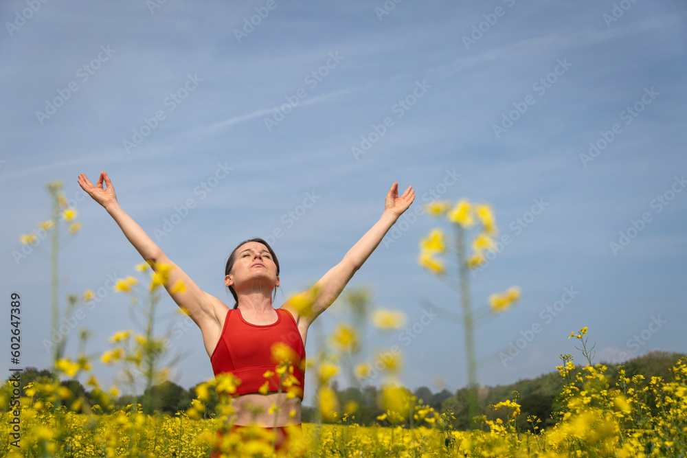woman celebrating life standing in nature with raised arms woman celebrating life standing in nature with raised arms
