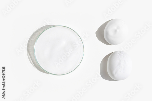 White foam in a Petri dish on a light background. Smears of foam on the background.