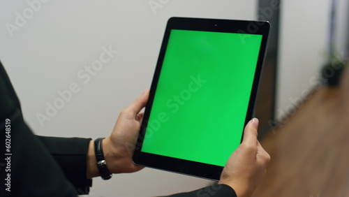 Hands holding green tablet template in office closeup. Employee video calling