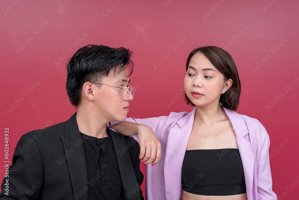 Portrait of professional man and woman with formal clothes posing side by side looking fierce and serious Isolated on a red background. Portrait of professional man and woman with formal clothes posing side by side looking fierce and serious Isolated on a red background.