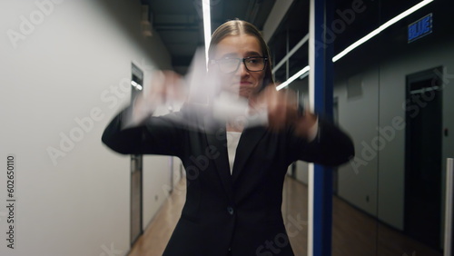 Unhappy businesswoman throwing documents in office corridor. Upset girl walking