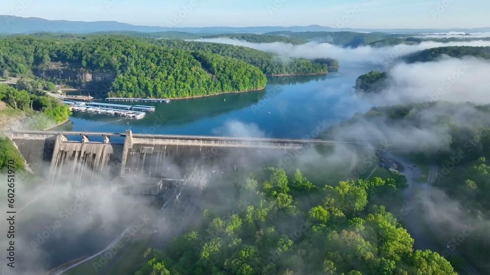 Norris Dam in Tennessee mountains at early morning sunlight beneath misty fog and clouds at daybreak